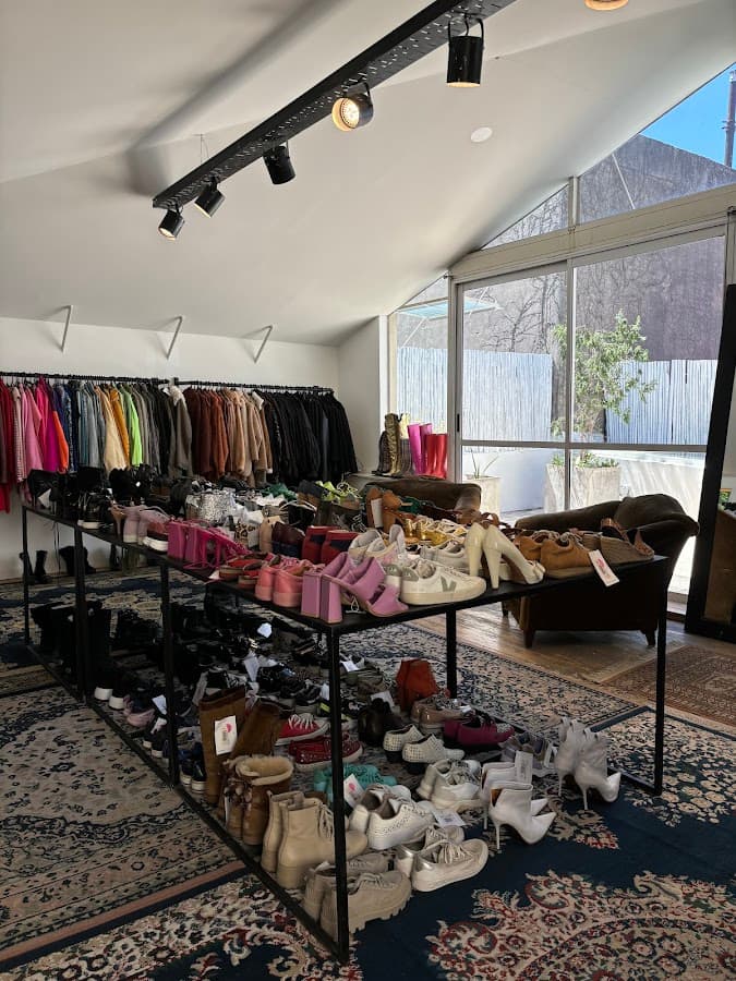 Interior de una feria americana en Villa Crespo, ropa vintage colgada en percheros